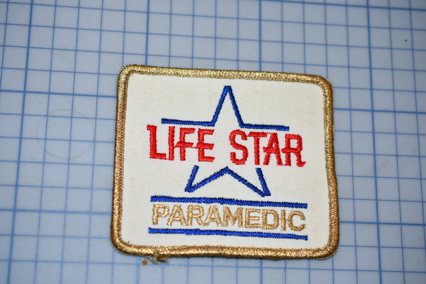a patch with the text "LIFE STAR PARAMEDIC" and a star symbol, indicating that it is a patch related to the Life Star Paramedic program.