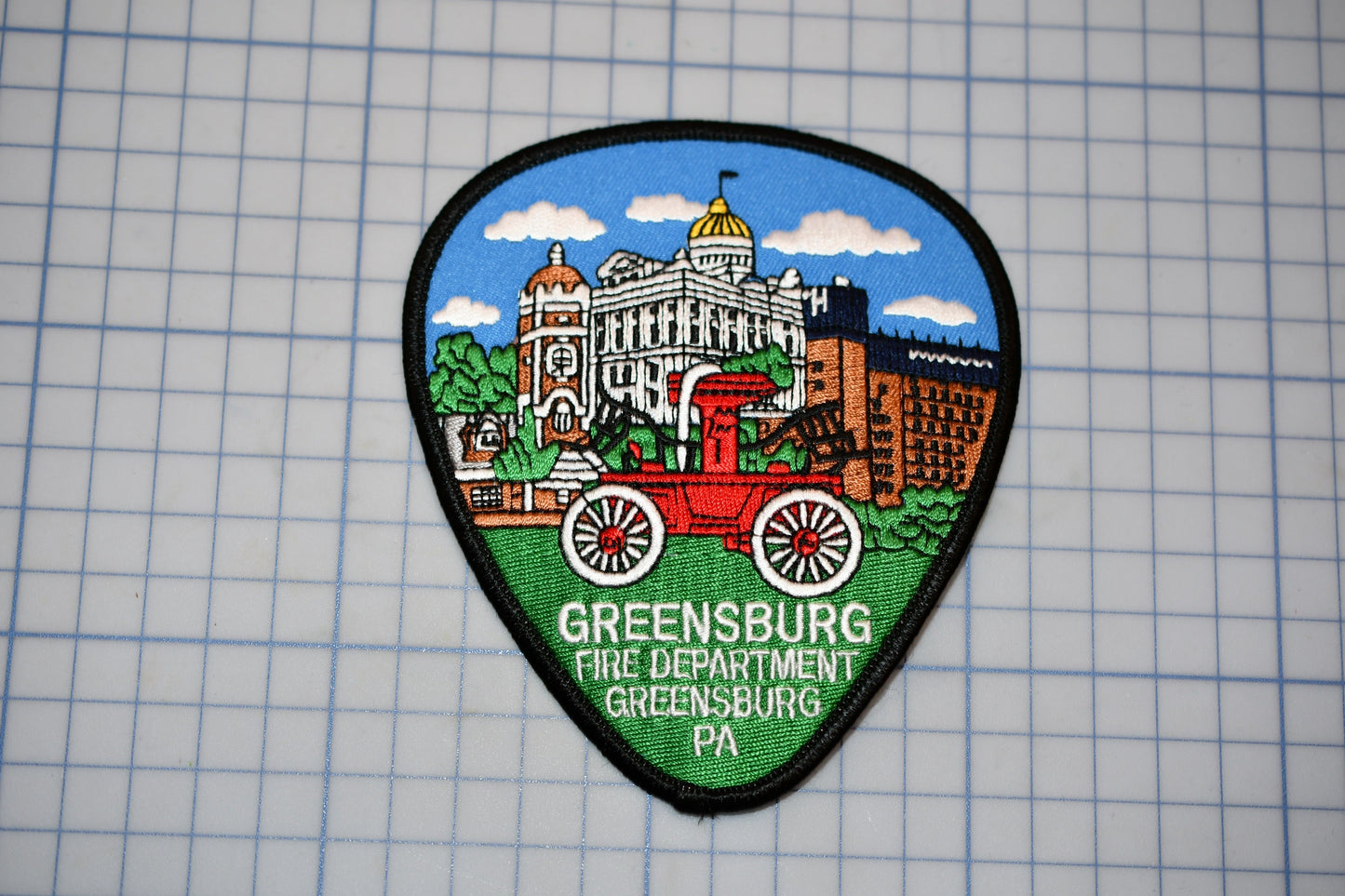 a patch with a picture of a building and a wagon