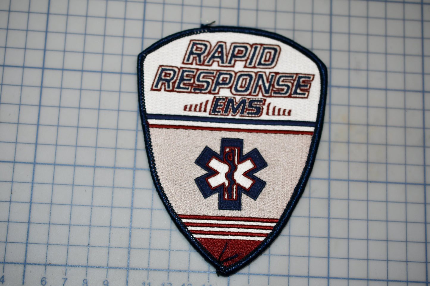 a patch with the text "RAPID RESPONSE EMS" and a medical symbol, likely representing a medical emergency response team or organization.