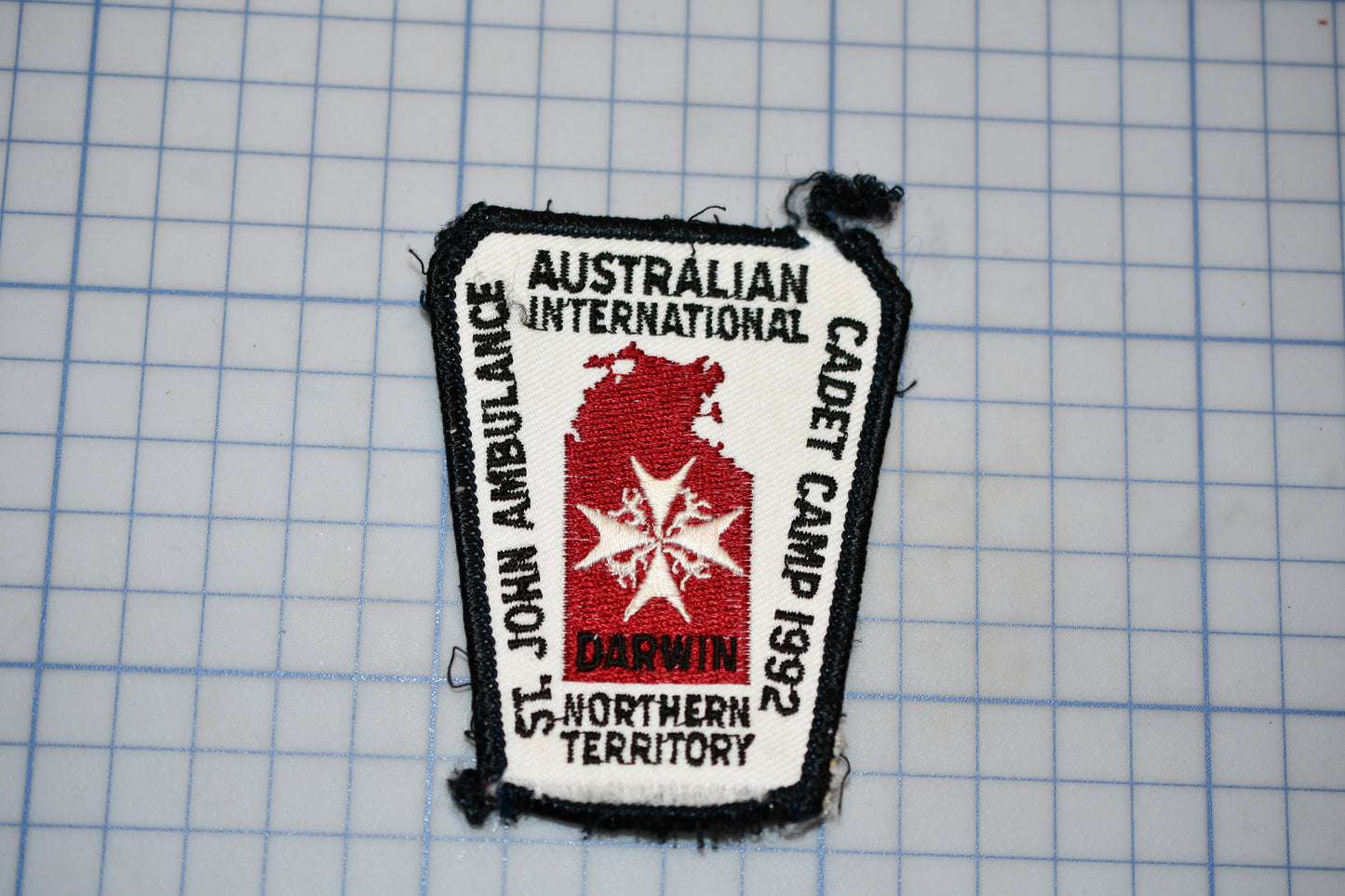 a patch with text and a red star, placed on a grid background.