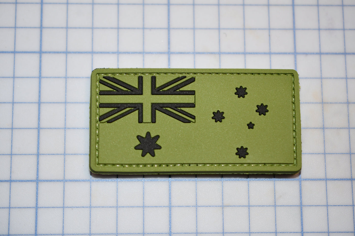 a green patch with a picture of a flag on it