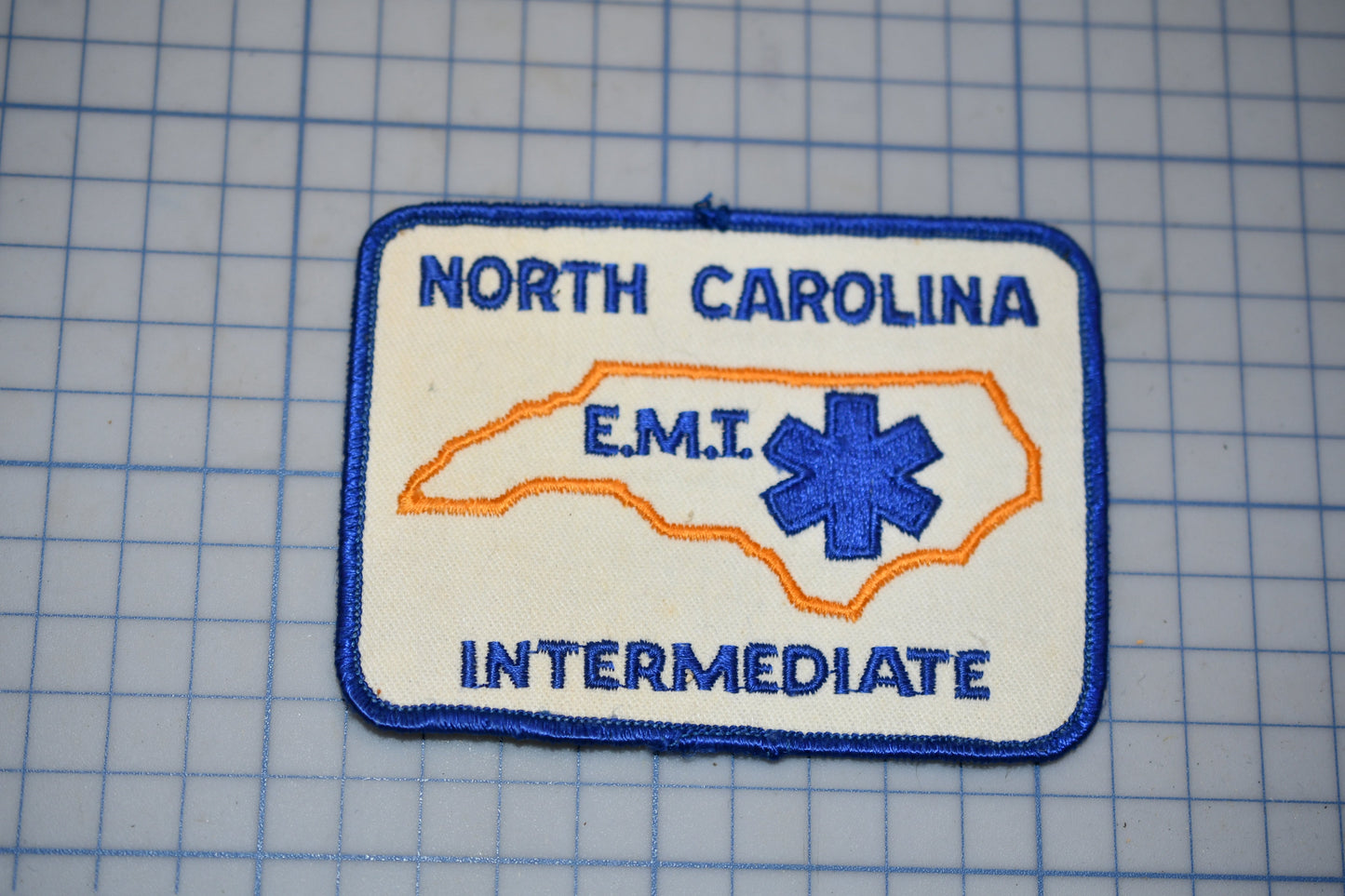 A patch with the text "NORTH CAROLINA EMT" and an outline of North Carolina, along with the word "INTERMEDIATE" below it.