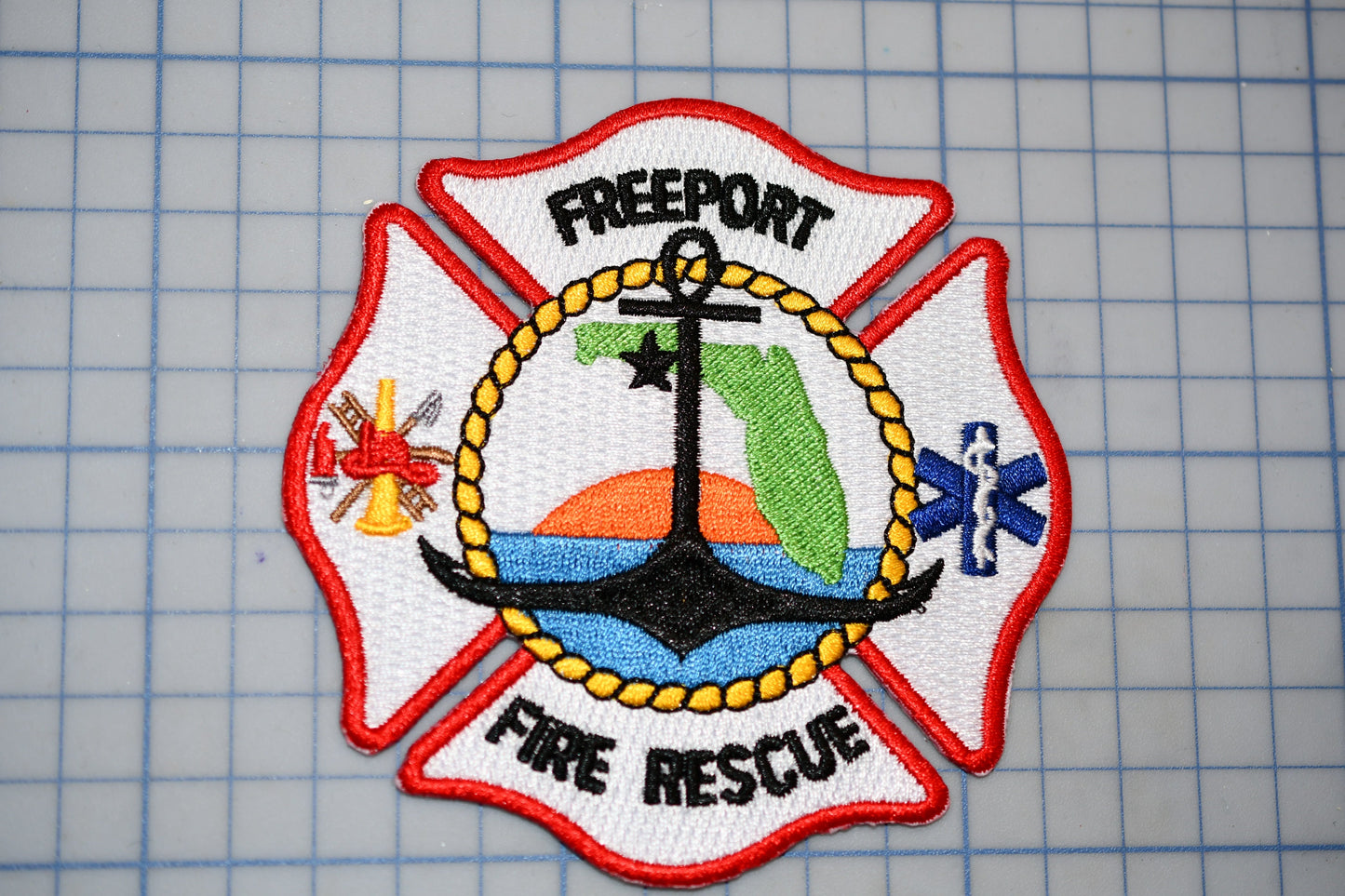 a fire rescue patch with a red and white color scheme, displaying various symbols and text related to the Freeport Fire Department.