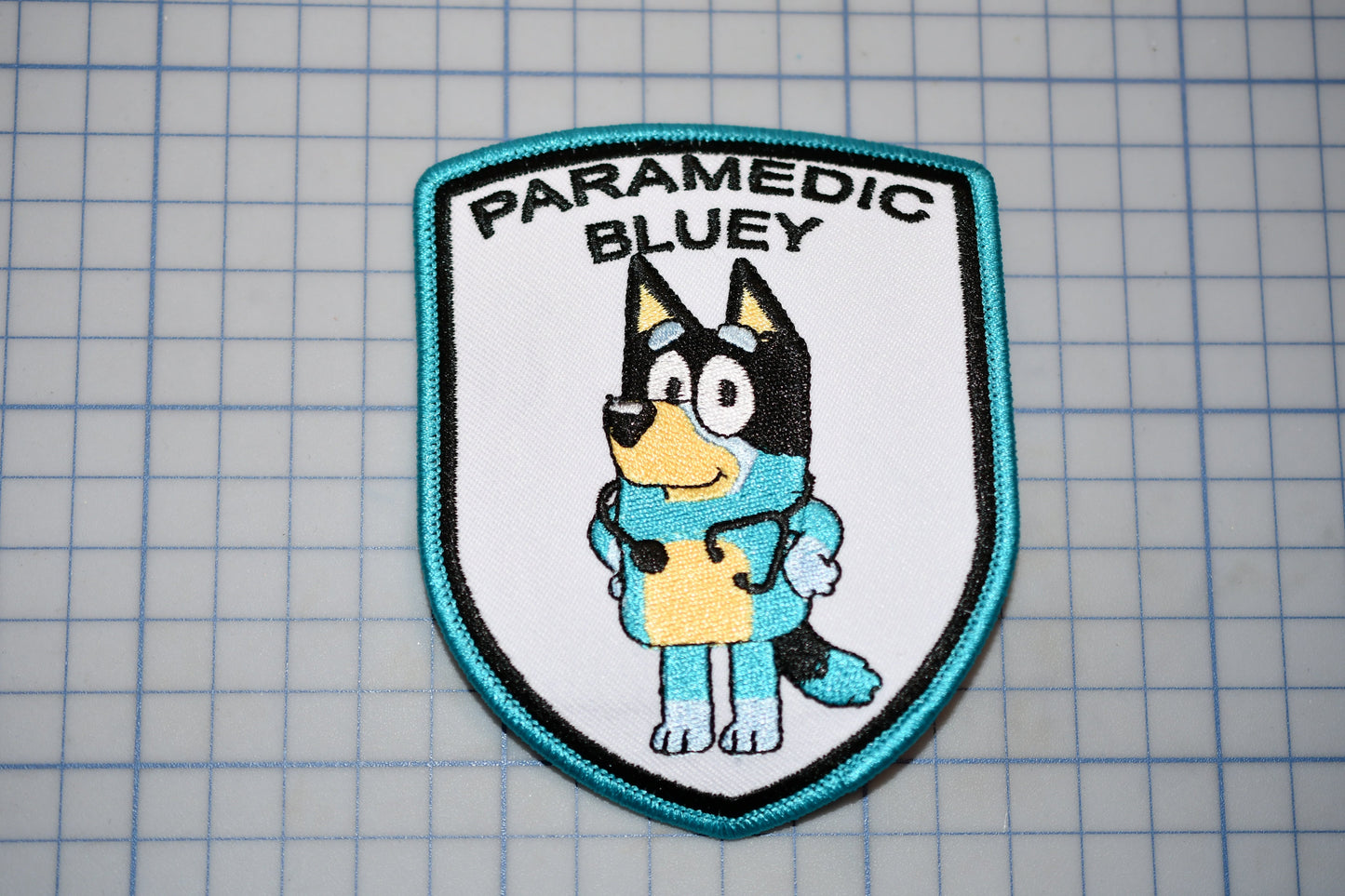 a patch with a dog on it that says paramedic bluey