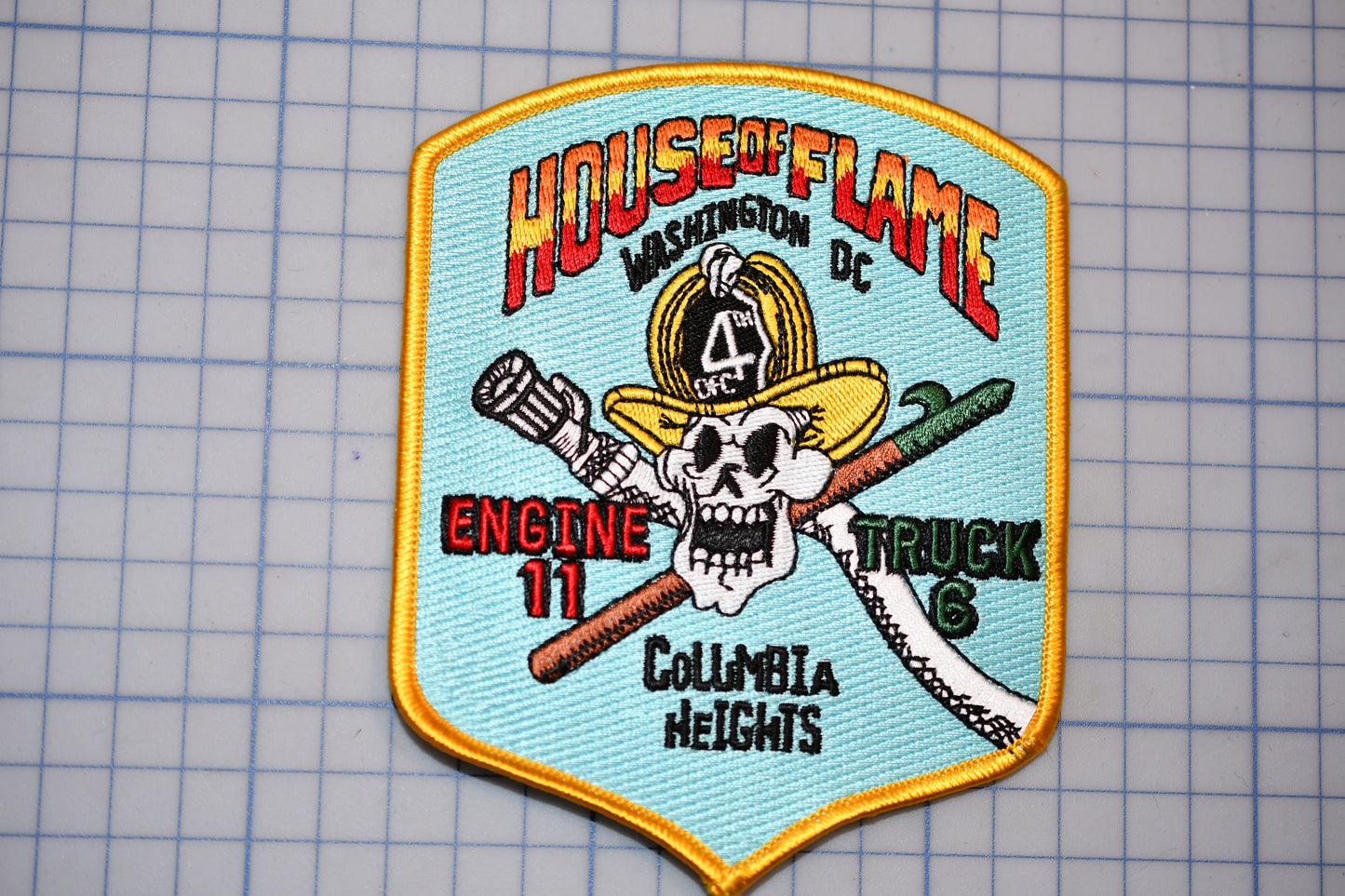 a patch with a stylized depiction of a firefighter and a skull, along with text that reads "House of Flame" and "Columbia Heights".