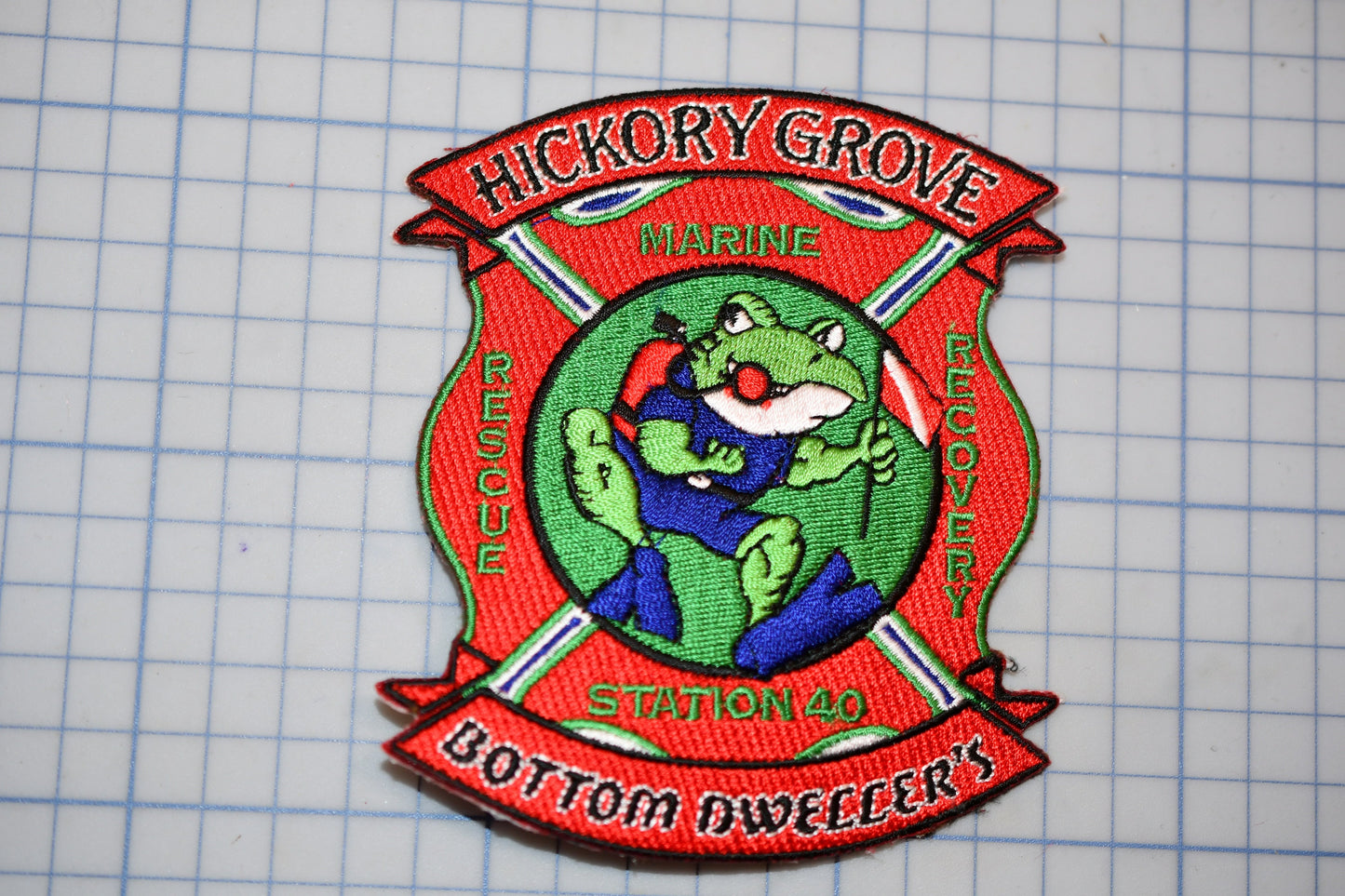 A fire department patch with a frog character, featuring the text "HICKORY GROVE MARINE RESCUE" and "STATION 40".
