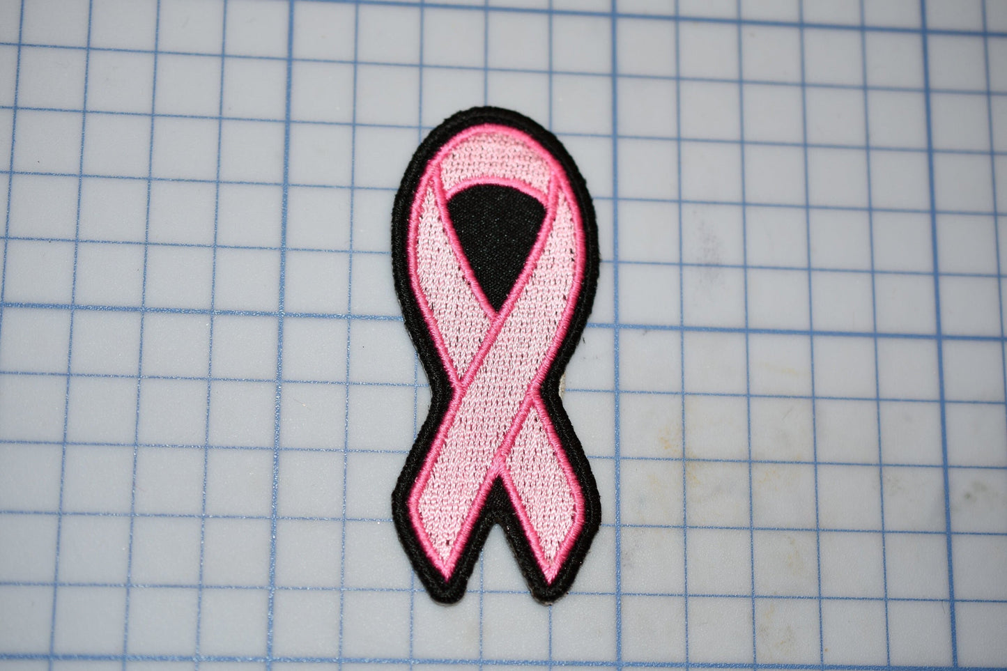 a pink ribbon on a piece of paper