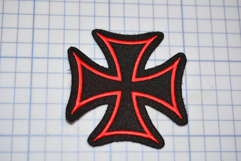 a red and black iron cross on a cutting board