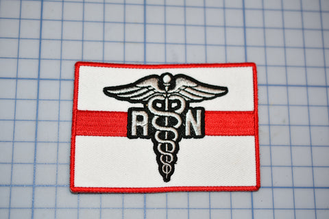a red and white patch with a medical symbol on it