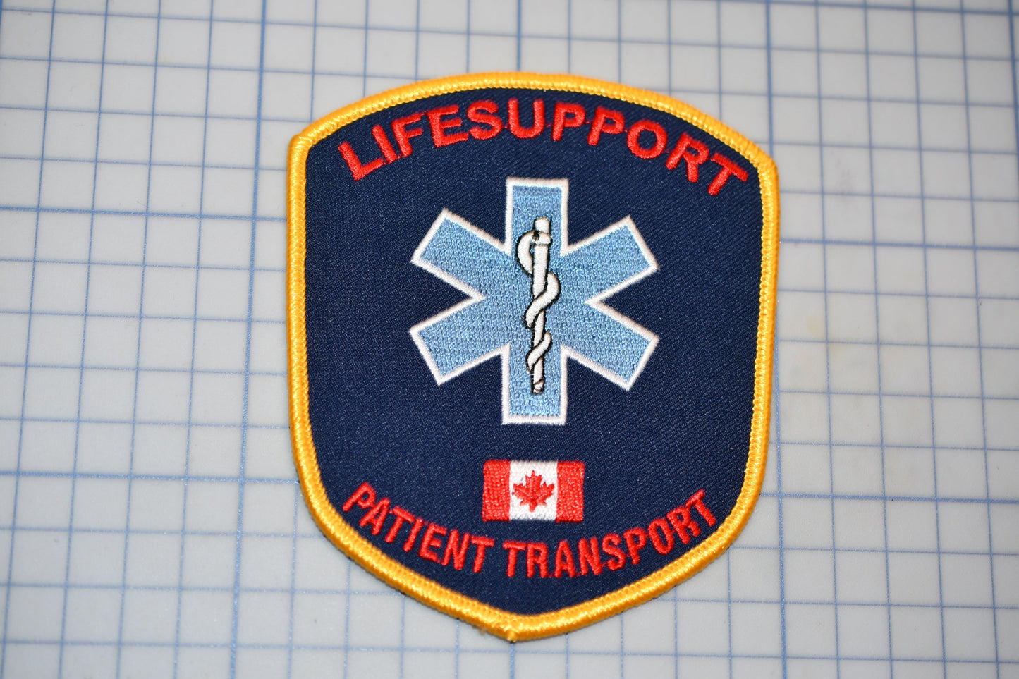 a patch with the word "LIFESUpport" and "Patient Transport" written on it, along with a medical symbol.