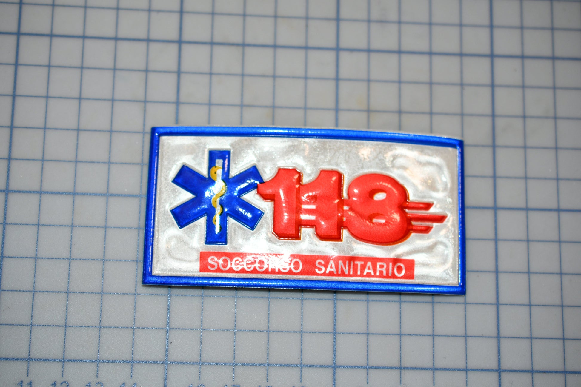 a badge with the number 118 and the text "SÁECO SANITARIO" on it.