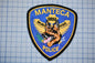 A police patch with a dog's head and wings, along with the text "MANTECA POLICE".