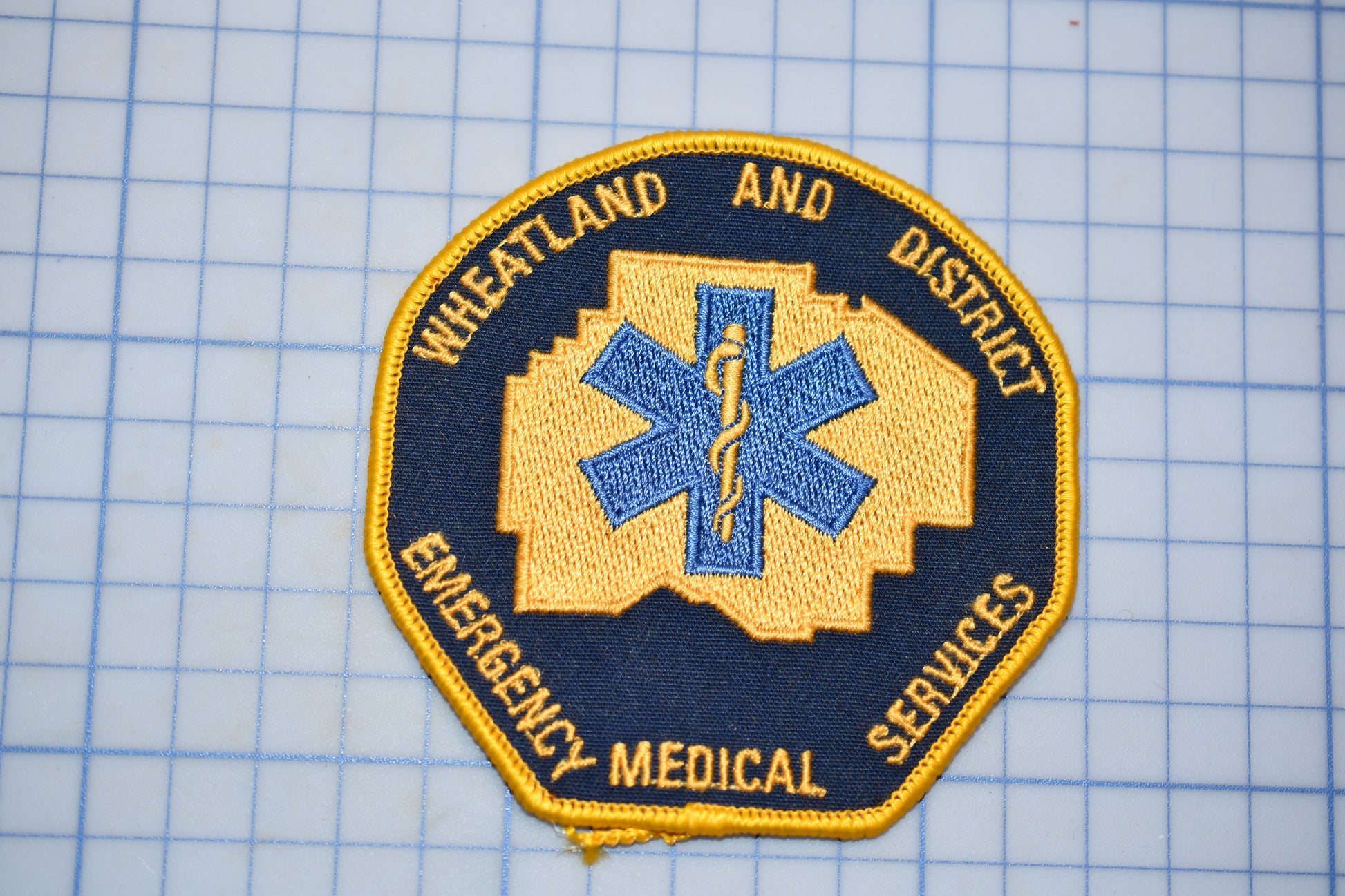 a patch with a medical symbol and text, likely representing emergency medical services.