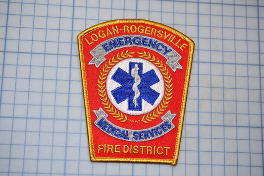 a red and gold emergency services patch with a blue and white medical cross symbol, indicating that it belongs to the Logan-Rogersville Fire District.