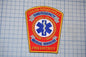 a red and gold emergency services patch with a blue and white medical cross symbol, indicating that it belongs to the Logan-Rogersville Fire District.