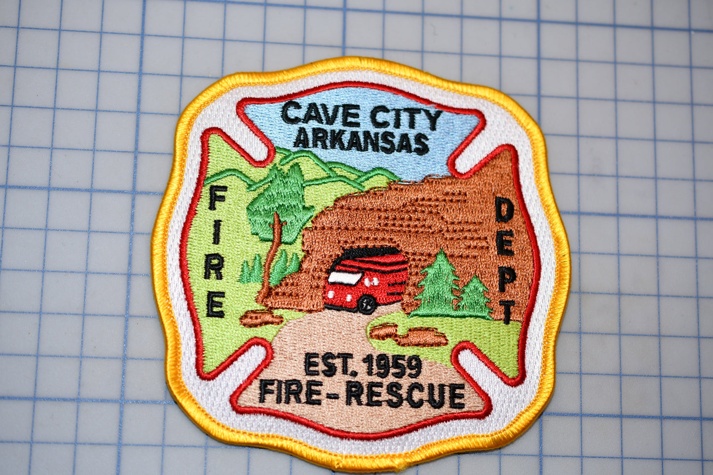 a fire department patch with a mountain landscape and a red fire truck.