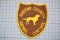 A brown and yellow patch with the text "GREENE COUNTY ANIMAL CONTROL" and a silhouette of a dog.