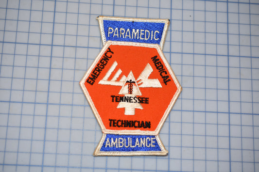 a patch with the words "PARAMEDIC", "EMERGENCY", "TENNESSEE", "TECHNICAL", and "AMBULANCE" printed on it, along with a medical symbol.