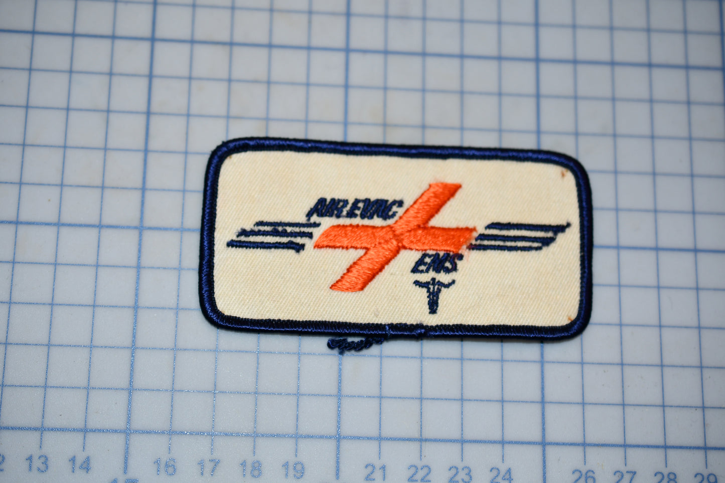 a patch with a logo, located on a grid background.