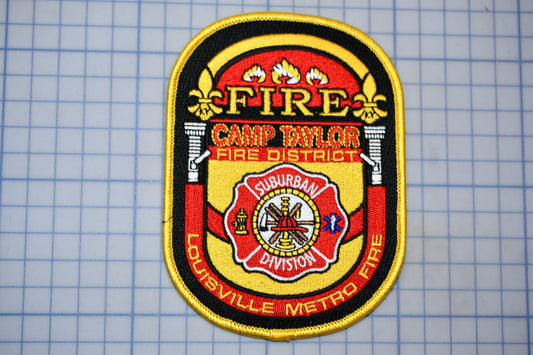 A fire department patch with the text "FIRE" and "CAMP TAYLOR FIRE DISTRICT" prominently displayed.