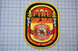 A fire department patch with the text "FIRE" and "CAMP TAYLOR FIRE DISTRICT" prominently displayed.