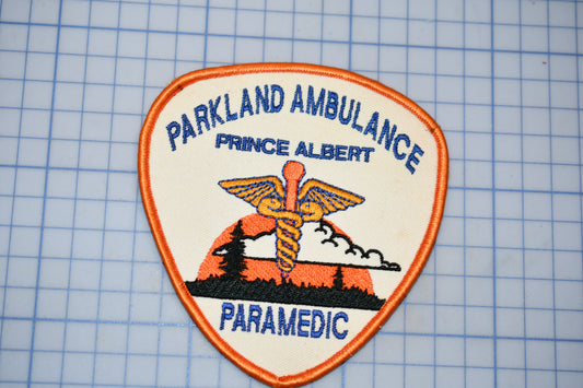 A badge or patch with the text "Parkland Ambulance" and "Prince Albert Paramedic" printed on it, along with an image of a medical symbol.
