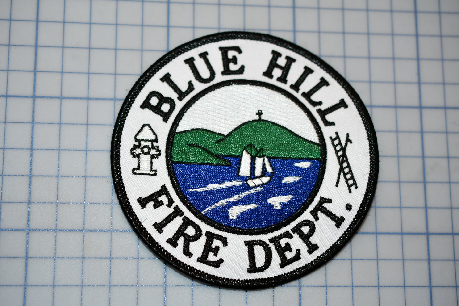 a blue hill fire department patch on a piece of paper