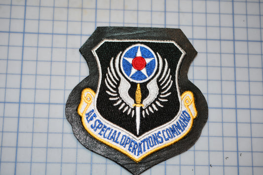 a black and gold emblem with a red star and a blue and white shield, which appears to be a military insignia.