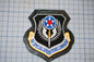 a black and gold emblem with a red star and a blue and white shield, which appears to be a military insignia.