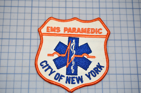 a patch with the text "EMS PARAMEDIC" and "CITY OF NEW YORK" on it, along with a blue and white medical symbol.