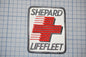 a patch with the text "SHEPARD LIFEFLEET" and a red cross symbol, which appears to be a logo or emblem associated with the company.