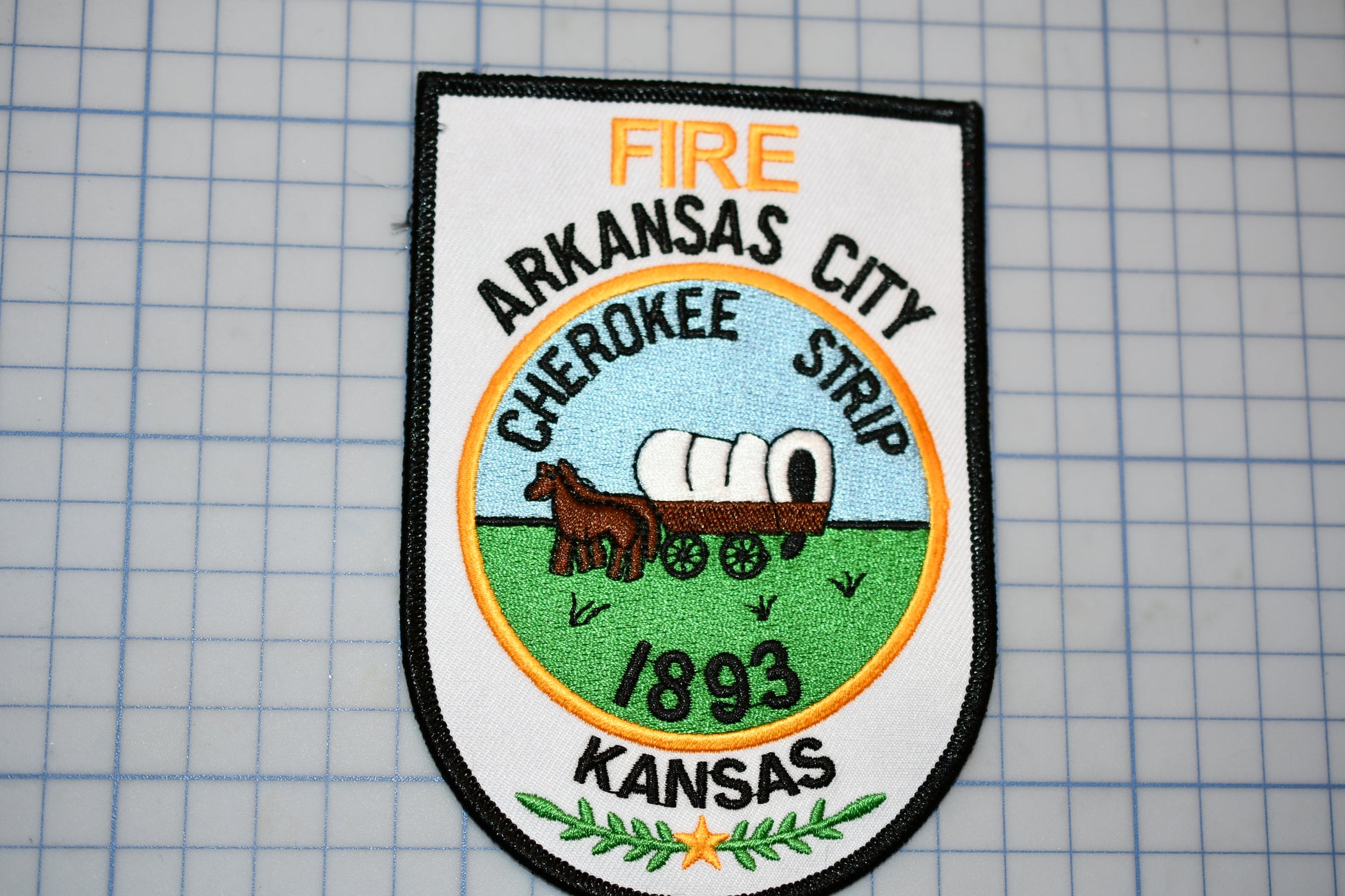 a patch with a picture of a horse drawn wagon