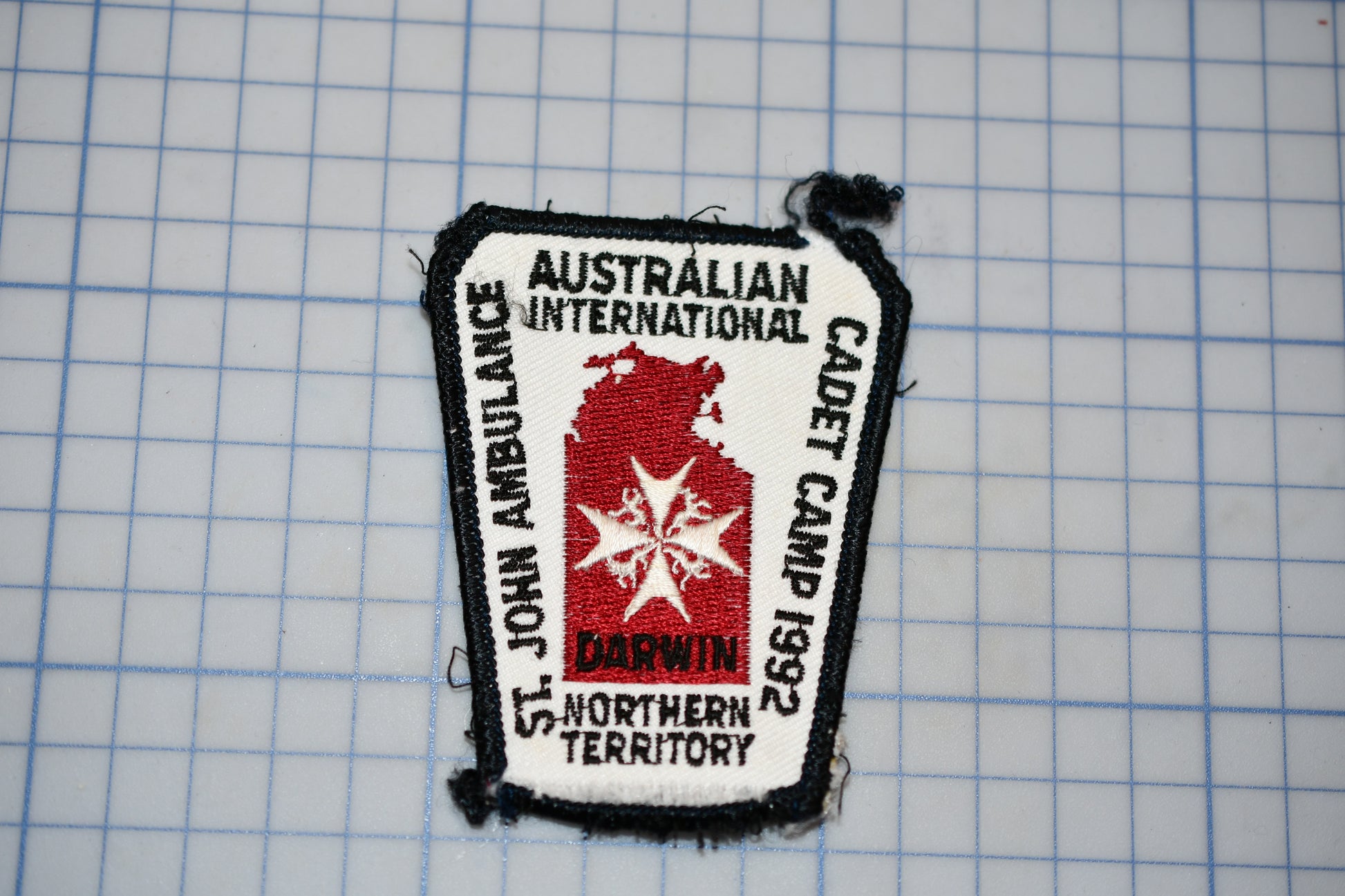 a patch with text and a red star, placed on a grid background.