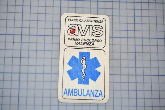 a white patch with text and a medical symbol, placed on a blue grid background.