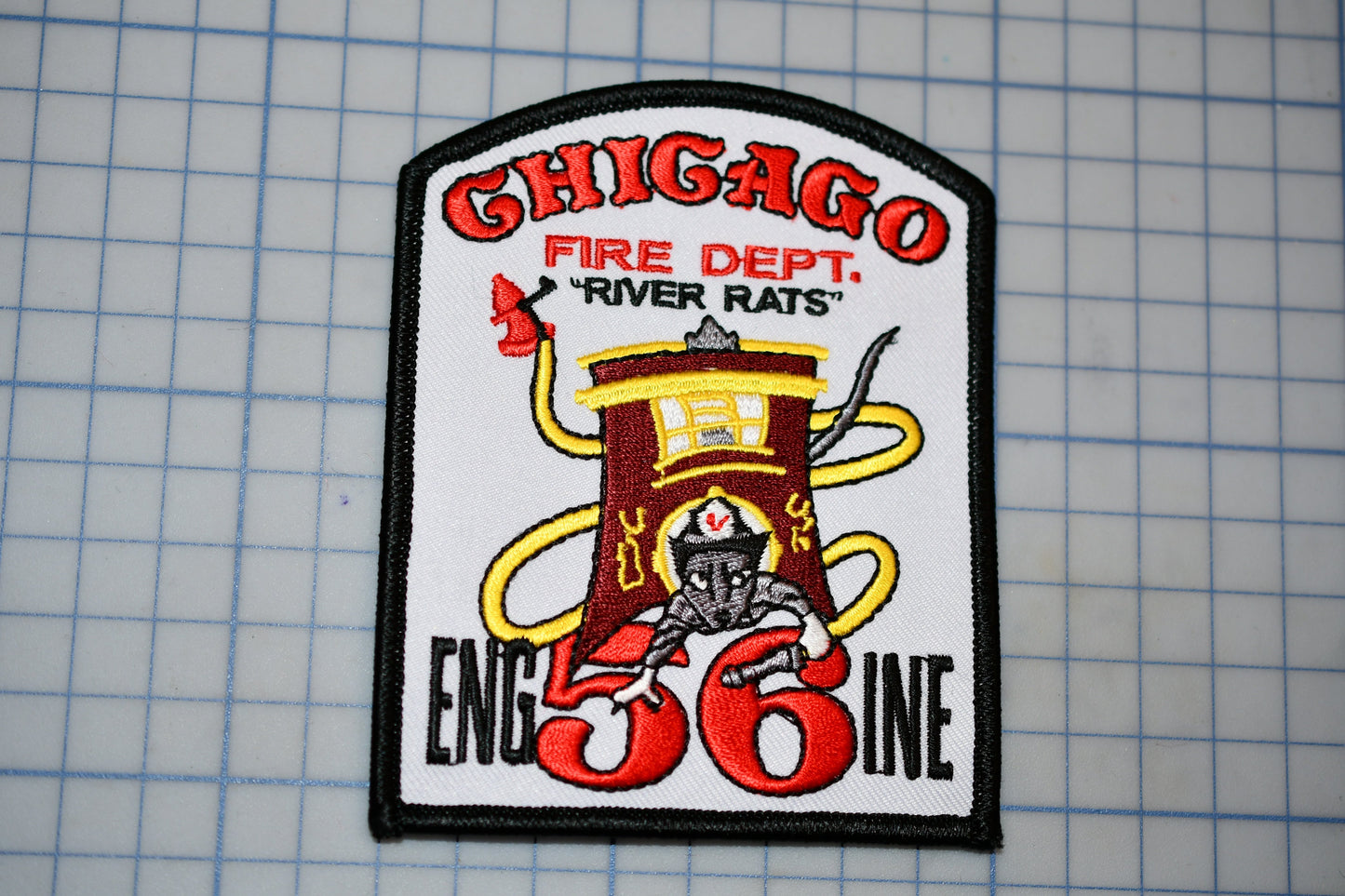 A patch with the text "CHICAGO FIRE DEPT. 'RIVER RATS'" and an illustration of a fire hydrant with a yellow hose. The patch also features the number "56" and the text "ENGIN 36".