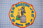 a fire department patch with a yellow background and a red border. The patch displays a statue of a man on a horse, a church steeple, and a building. The text on the patch reads "BOSTON LAD. 1 NORTH END".