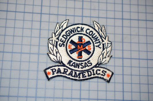 a badge or patch with the text "Sedgwick County Kansas Paramedics" and a medical symbol, likely representing a medical emergency response team.