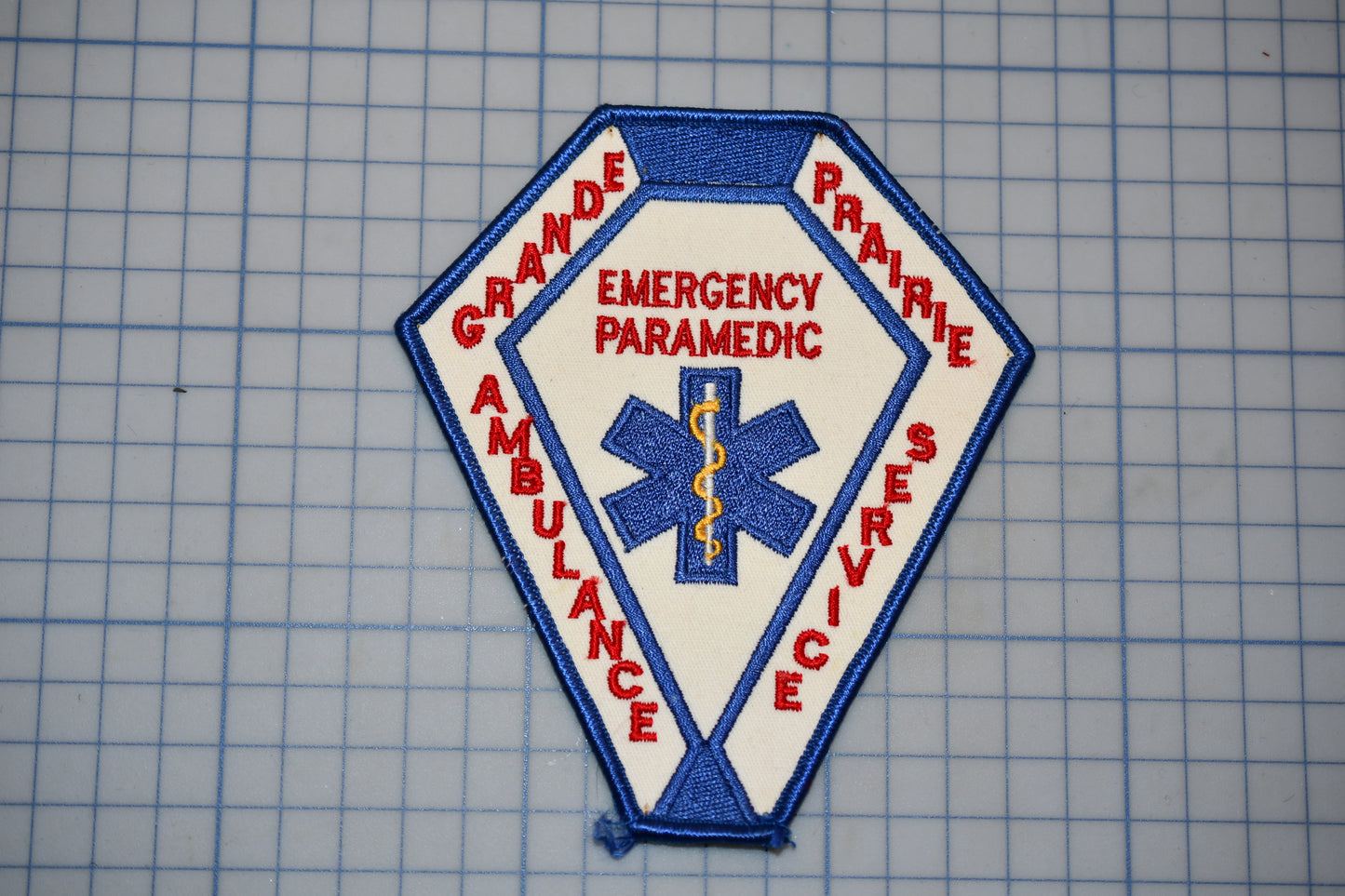 a patch with the words "EMERGENCY PARAMEDIC" and "AMBULANCE SERVICE" written on it, along with a medical symbol.