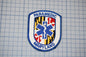a Paramedic Maryland patch, which is a blue and white shield-shaped emblem with a medical cross and the text "PARAMEDIC MARYLAND" printed on it.
