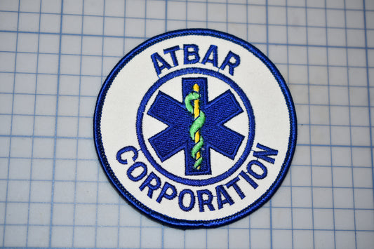 a circular patch with the text "ATBAR CORPORATION" and a medical symbol, such as a cross or stethoscope, prominently displayed.