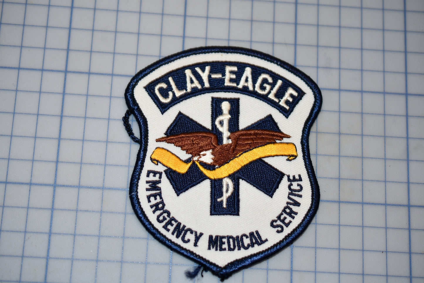a medical service patch with the text "CLAY-EAGLE EMERGENCY MEDICAL SERVICE".