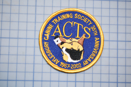a circular patch with a blue background and gold border, displaying the text "CANINE TRAINING SOCIETY 35TH ANNIVERSARY 1967-2002" around the edge.