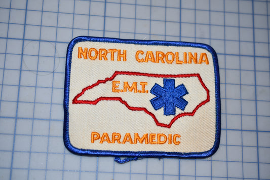 a patch with the text "NORTH CAROLINA EMT PARAMEDIC" and a blue star-shaped symbol, representing the emergency medical services of North Carolina.