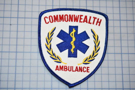 a patch with the text "Commonwealth Ambulance" and a medical symbol, such as a cross or a snake, on it.