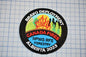 A badge with the text "BRAVO DEPLOYMENT" at the top, "CANADA FIRES" in the center, and "NPWS RFS FORESTYLE" at the bottom. The badge is placed on a grid background.