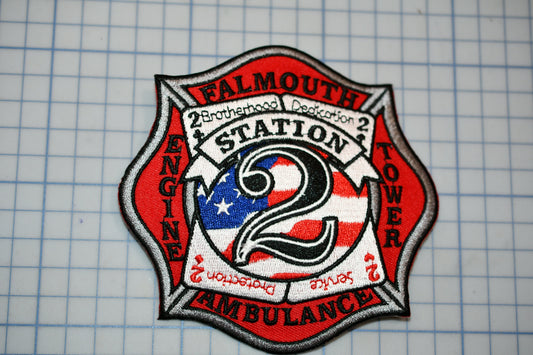 a fire department patch with the words "Falmouth Station 2 Ambulance" and an American flag design.