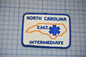 A patch with the text "NORTH CAROLINA EMT" and an outline of North Carolina, along with the word "INTERMEDIATE" below it.