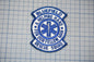 A blue and white patch with the text "BLUEFIELD A HELPING HAND FOR OUR FELLOW MAN RESCUE SQUAD" and a medical symbol, indicating that it is a patch representing the Bluefield Rescue Squad.