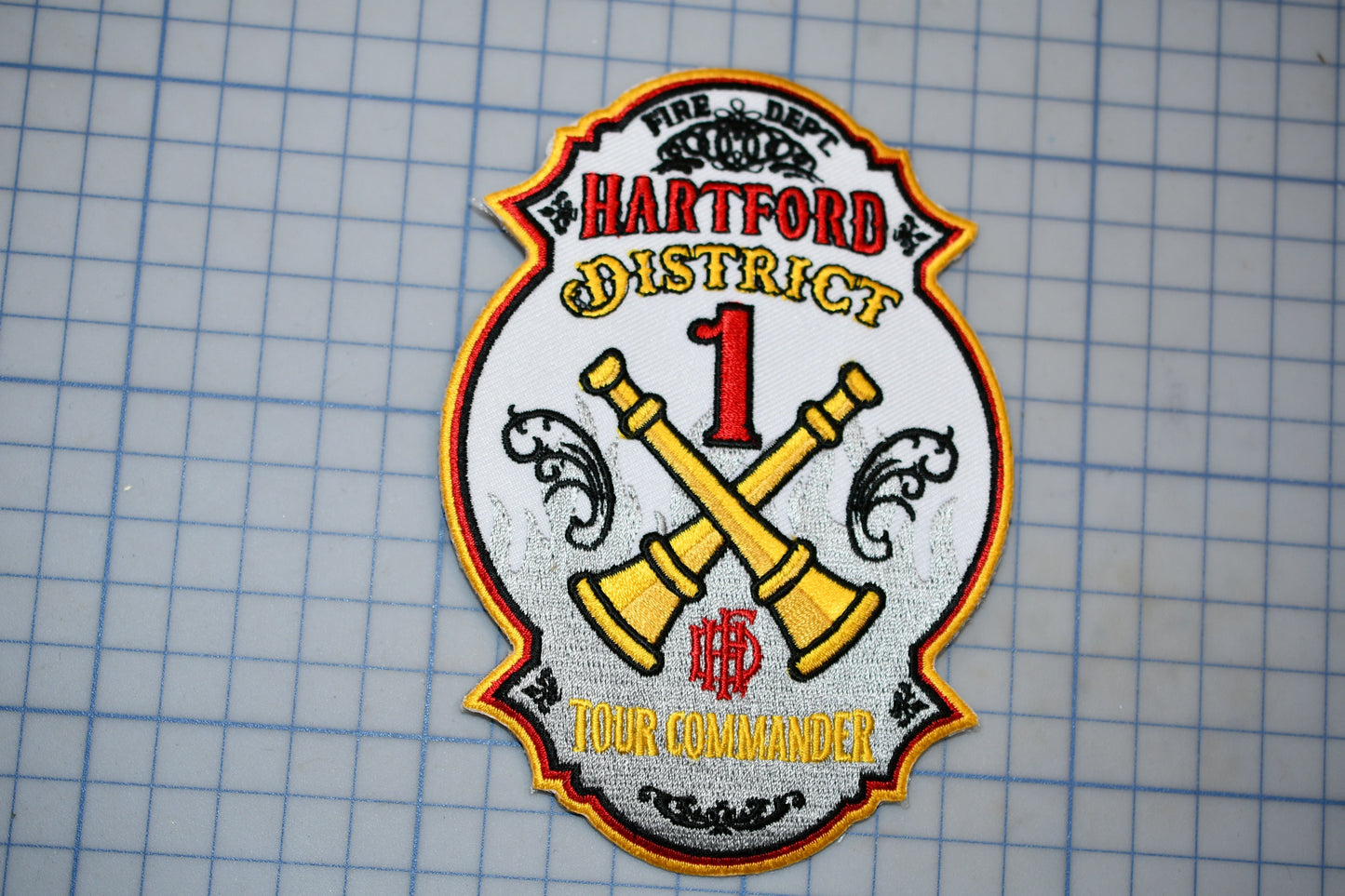 a fire department patch with the text "HARTFORD DISTRICT 1" and "TOUR COMMANDER" printed on it.