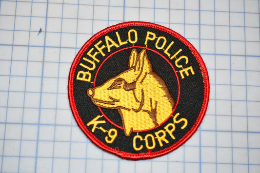 A circular patch with a yellow dog's head and the text "BUFFALO POLICE K-9 CORPS" printed on it.